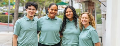 Team of staff members posing outside the facility