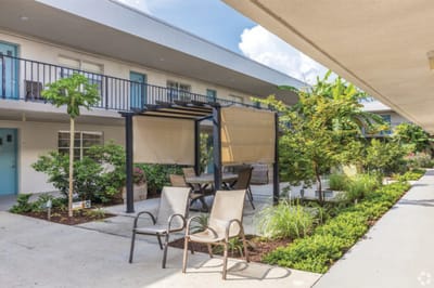 Outdoor seating area with potted plants and shaded table