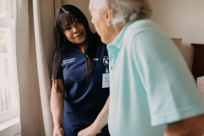 Caregiver assisting a senior resident indoors