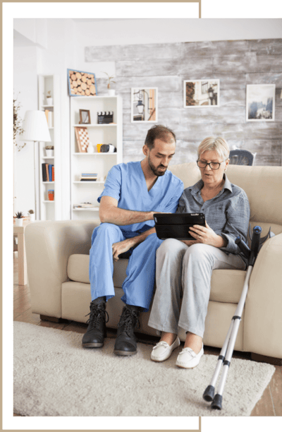 Staff member assisting a resident with a tablet