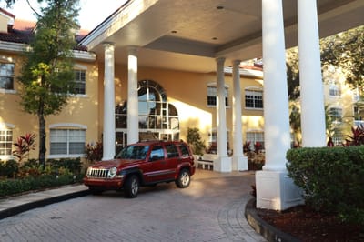 Front entrance of The Pointe at Plantation with vehicle