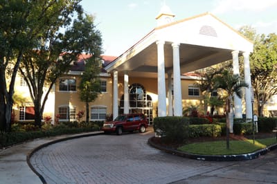 Exterior view of The Pointe at Plantation with entrance and vehicle
