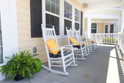 Porch with rocking chairs and yellow cushions