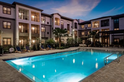 Pool area with lounge chairs and building view