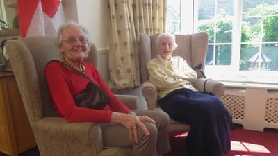 Two residents enjoying time in a cozy lounge area