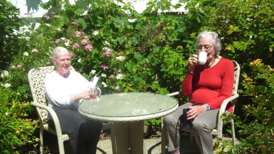 Two women enjoying drinks in a garden