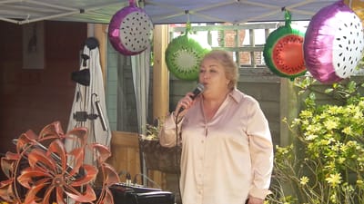 A woman singing at an outdoor celebration event