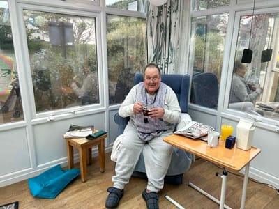 A resident enjoying a beverage in a sunlit room