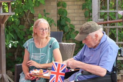 Residents enjoying snacks in an outdoor space with a flag