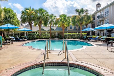 Swimming pool area with lounge chairs and umbrellas