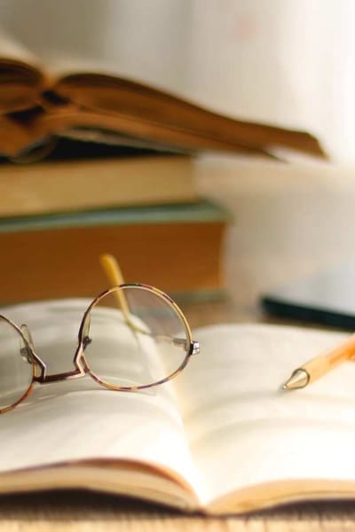 Reading glasses and an open book on a table