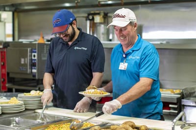 Staff serving food in the dining area
