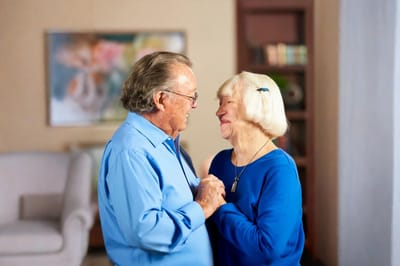 A couple smiling and holding hands in an interior setting