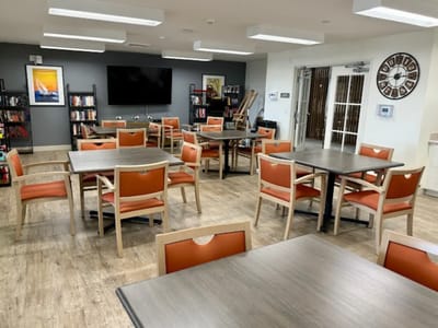 A brightly lit common area with seating and bookshelves