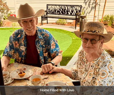 Two residents enjoying tea outdoors at a beautifully set table