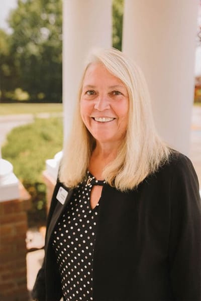 Smiling staff member standing outside the facility