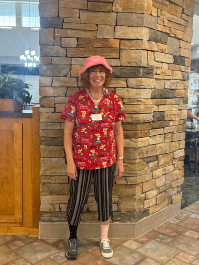 Staff member in colorful attire within facility interior