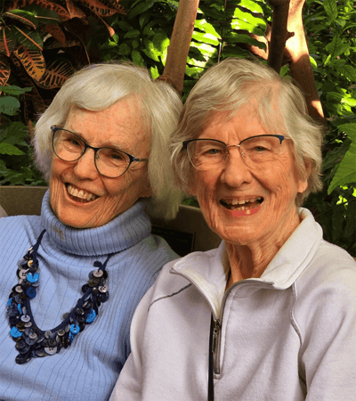 Two happy residents posing together outdoors