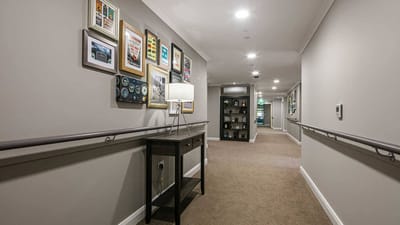 Bright interior hallway with framed art and seating