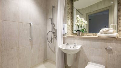 Modern bathroom with grab bars and flowers