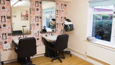 Hair salon area with styling chairs and mirrors