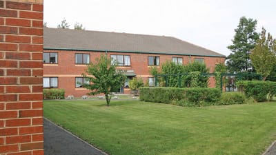 Exterior view of the facility surrounded by gardens