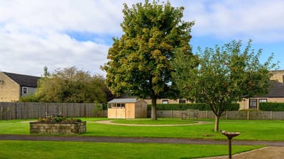 Well-kept garden area with trees and a shed