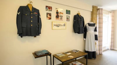 Historical military uniforms displayed on a wall