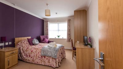 Cozy resident room with floral bedding and natural light