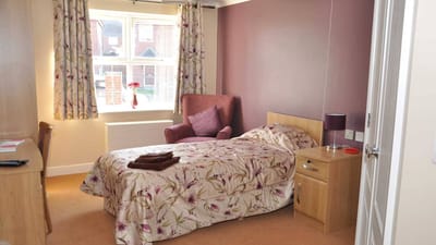 Cozy resident room with floral bedding and natural light