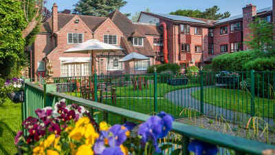 Exterior view of a senior living facility with gardens