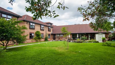 Exterior view of assisted living facility with garden