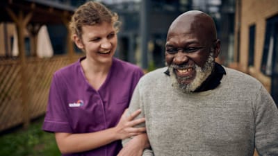Smiling resident and caregiver enjoying time outdoors