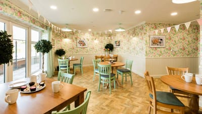 Bright dining room with floral wallpaper and tables