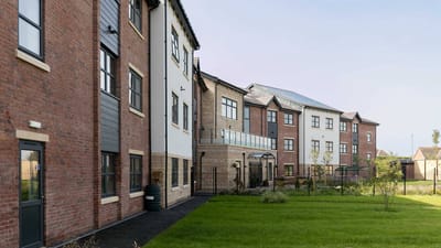 Exterior view of a senior living facility with garden