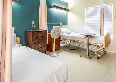 A shared resident room with two beds and furniture