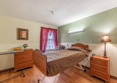 Cozy private room with a hospital bed and dresser