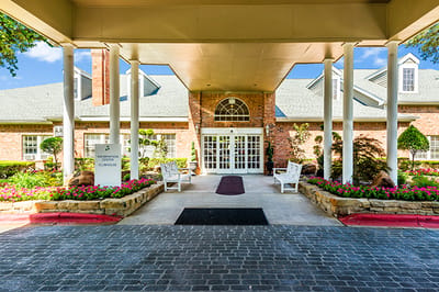 Entrance of a senior living facility with landscaped gardens
