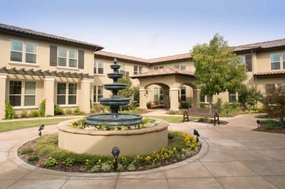 Outdoor courtyard featuring a fountain and landscaped garden