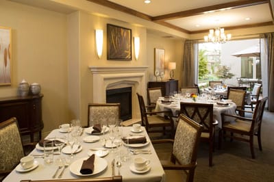 Dining room with elegantly set tables and a fireplace
