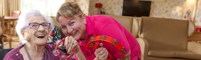 Staff member and resident enjoying a musical activity