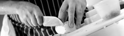 Hands preparing food in a kitchen setting