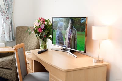 Cozy resident room with flowers and a TV