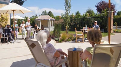Residents enjoying a sunny outdoor activity space