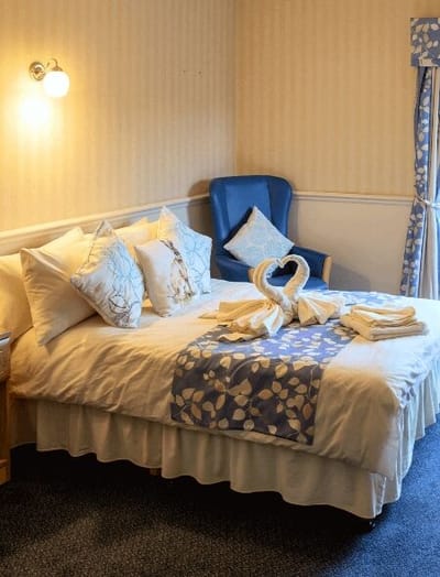 Well-decorated private resident room with a bed and armchair