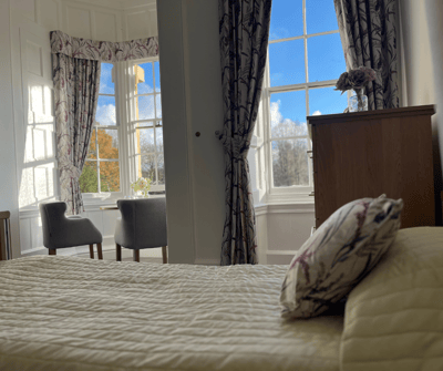 Bright resident room with large windows and cozy decor