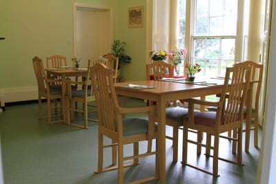 Bright dining area with tall windows and wooden tables