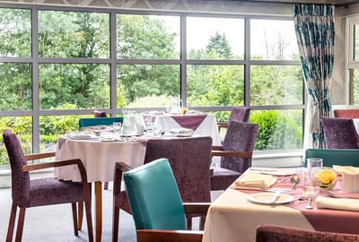 Dining area with tables and greenery outside