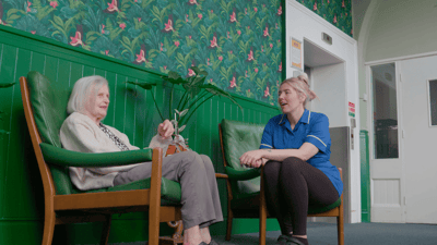 Staff member conversing with a resident in a lounge area