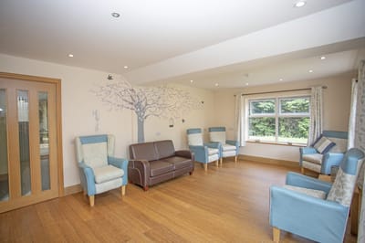 Bright, spacious common area with chairs and a mural